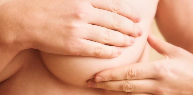 Hand gaat over borst voor borstonderzoek