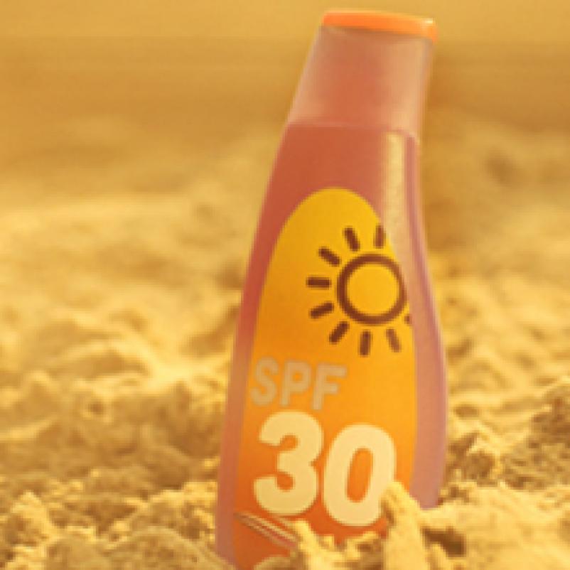 Fles zonnebrandcreme in het zand