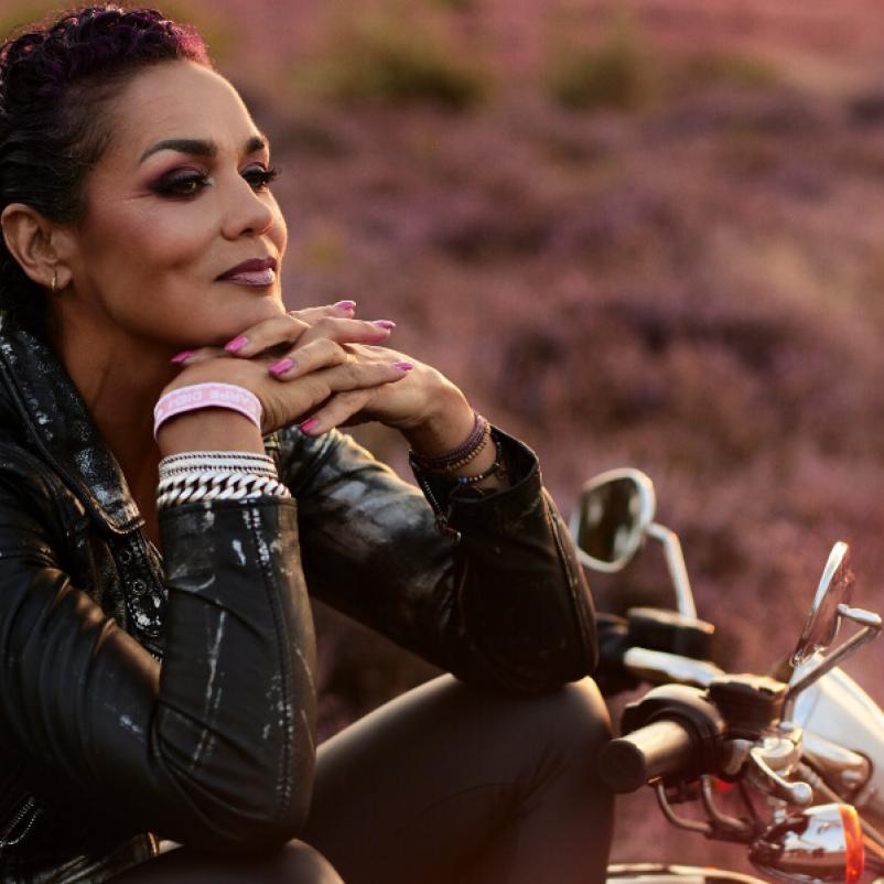 Vrouw met  motor in bloeiend heideveld