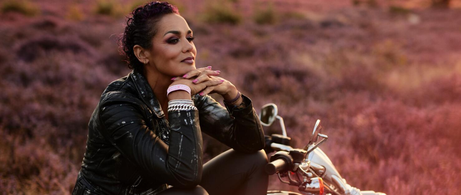 Vrouw met  motor in bloeiend heideveld