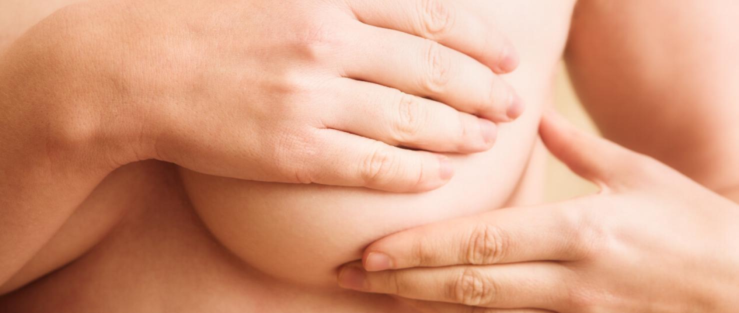 Hand gaat over borst voor borstonderzoek